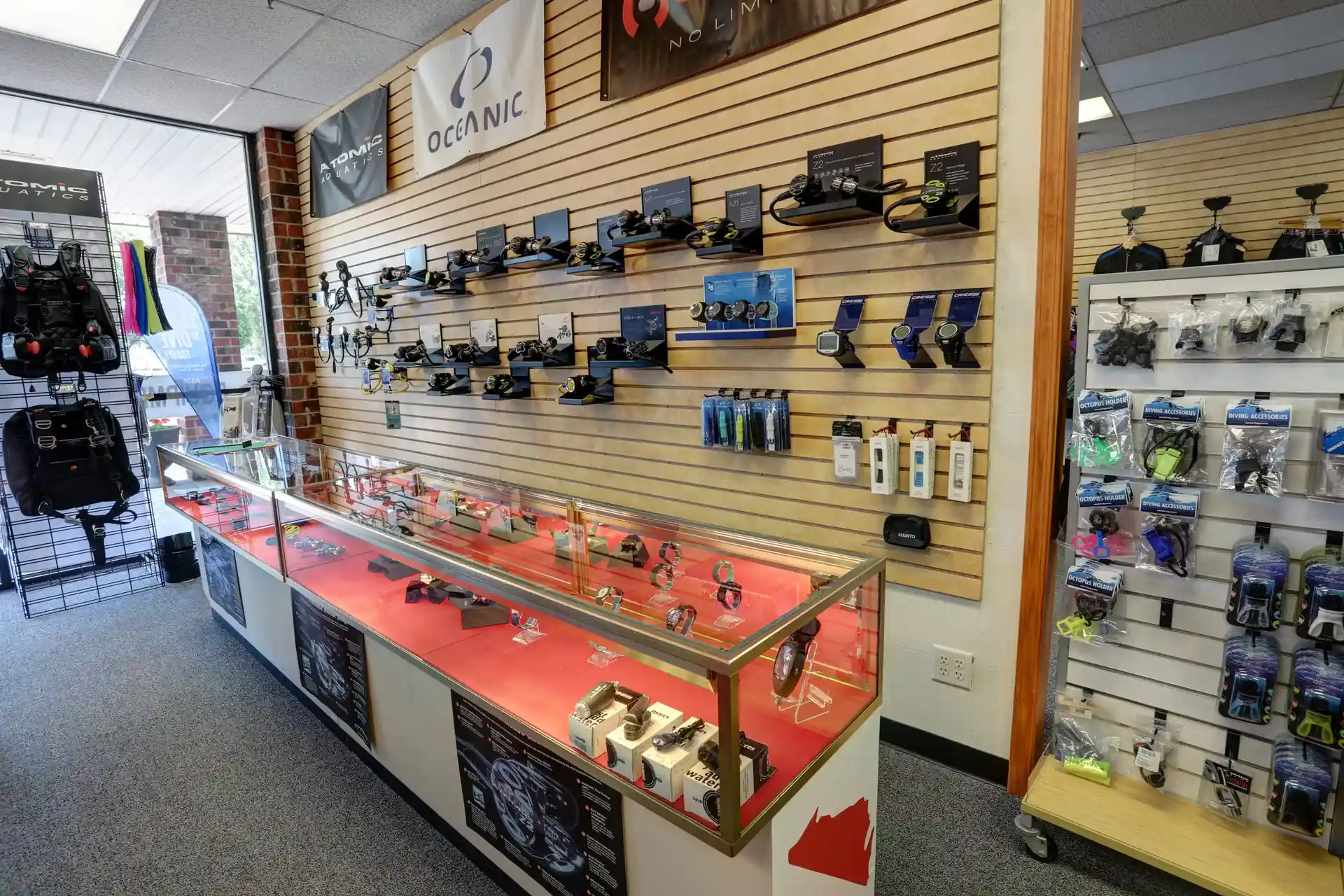 Sales display of regulators on the wall and dive computers in the glass cabinet.