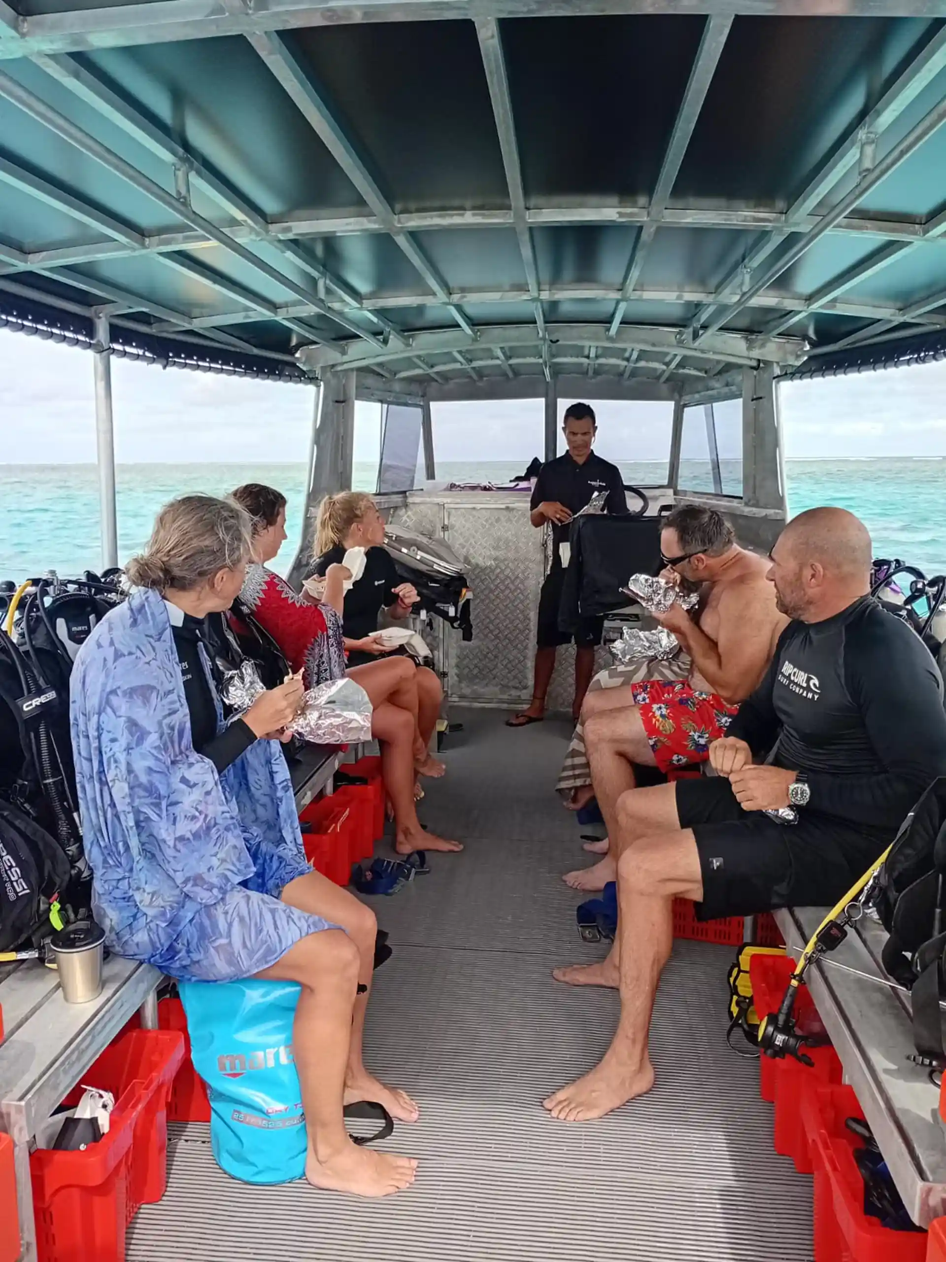 Divers enjoying surface interval chicken salad wraps with the team