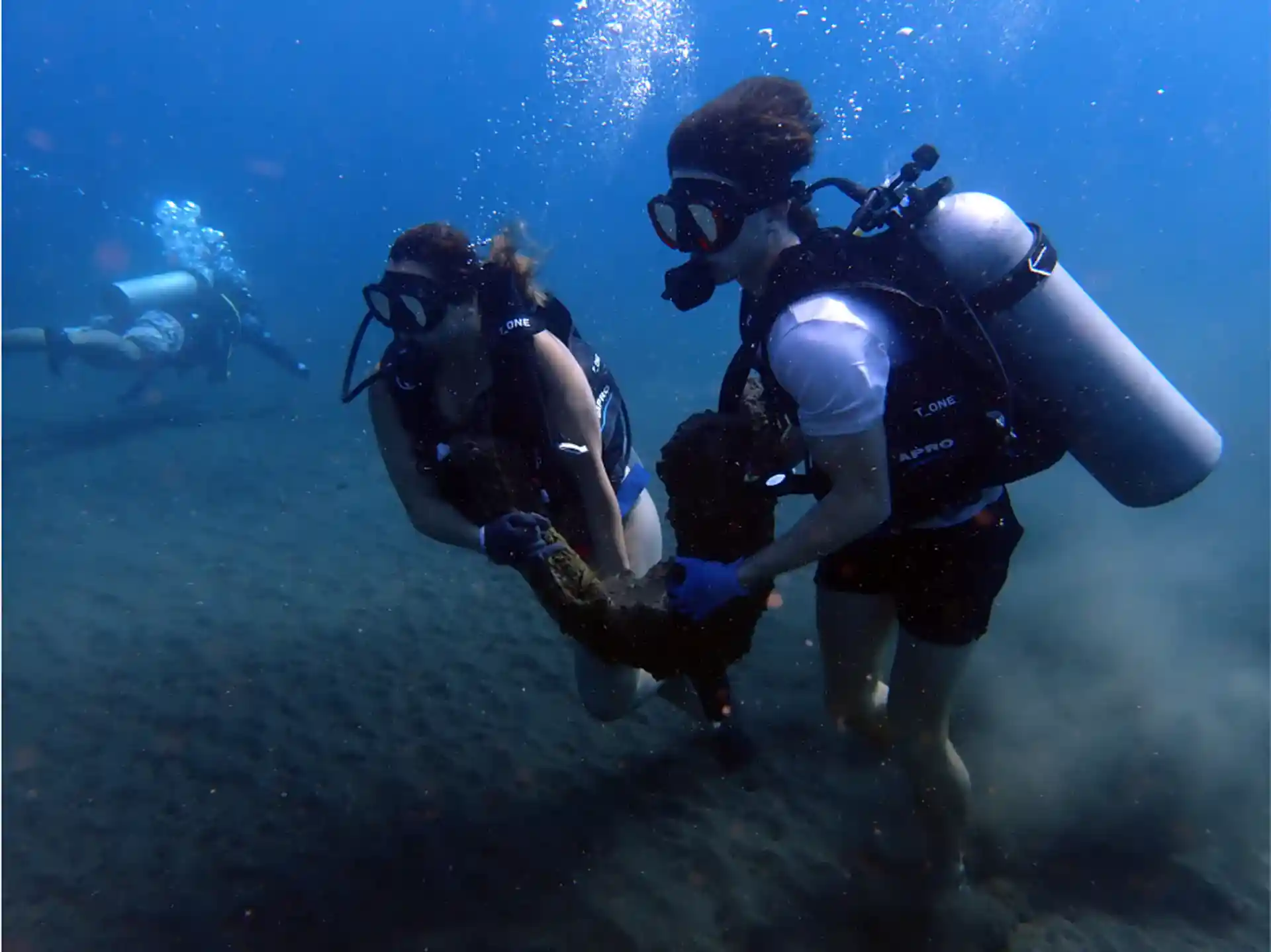 BCD divers buddy team deploying an artificial reef structure in Kubu, Bali